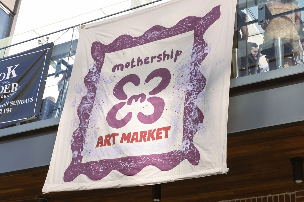 The Mothership Art Market banner hanging at Hotel West & Main