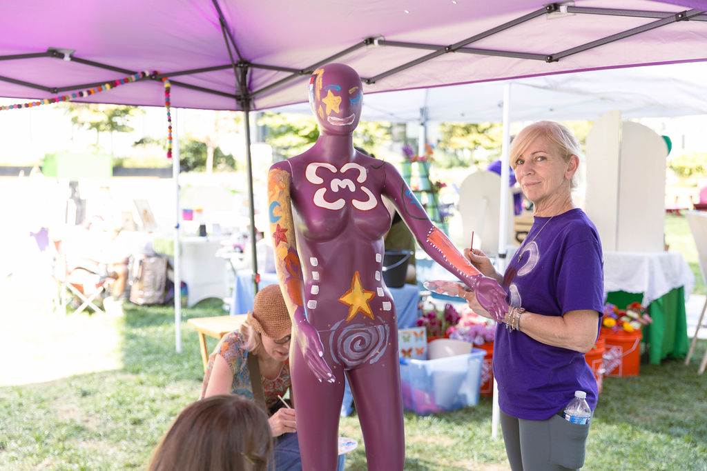 Esmeralda, a hand-painted mannequin community art installation, on display under the market tent
