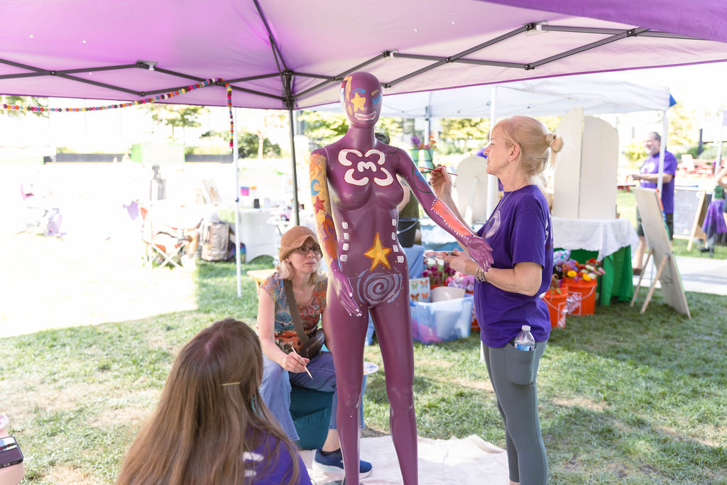 Artist body-painting a mannequin at the market